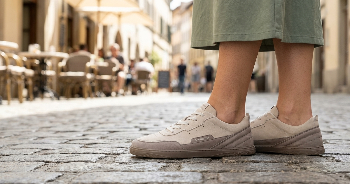 Varios pies con distintas zapatillas barefoot sobre suelo empedrado
