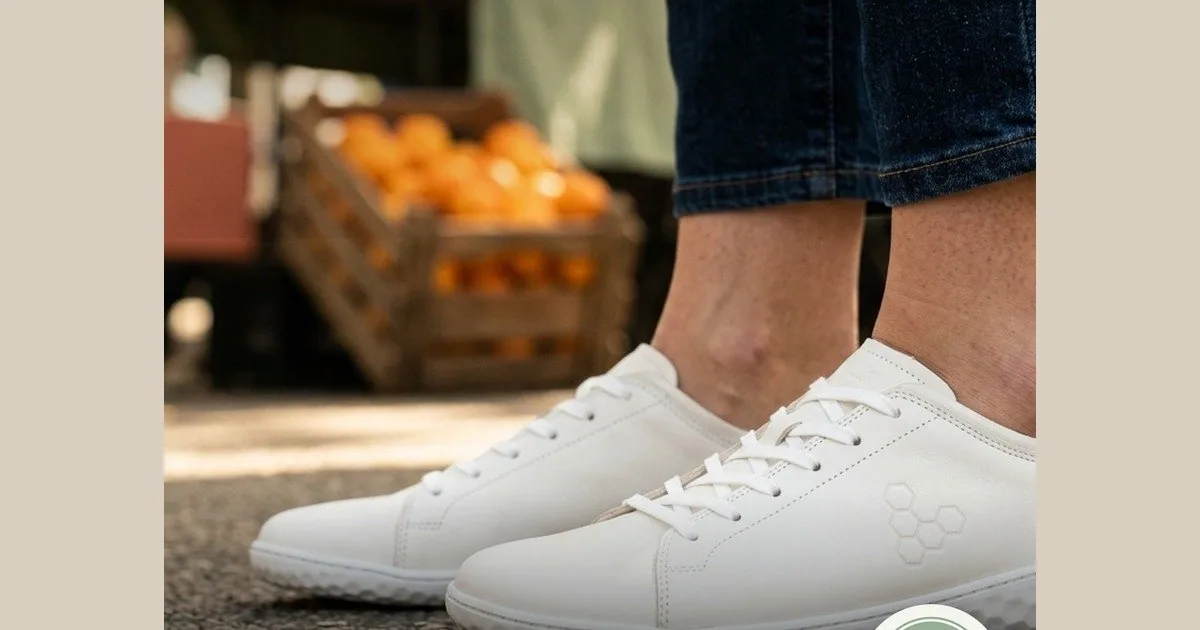 Persona de pie con las Vivobarefoot Geo Court III blancas, el modelo que lleva la Reina Letizia, las dos zapatillas completas a la vista.